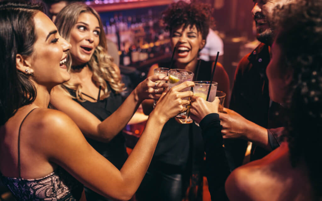 Group of people having fun and clinking glasses in unison